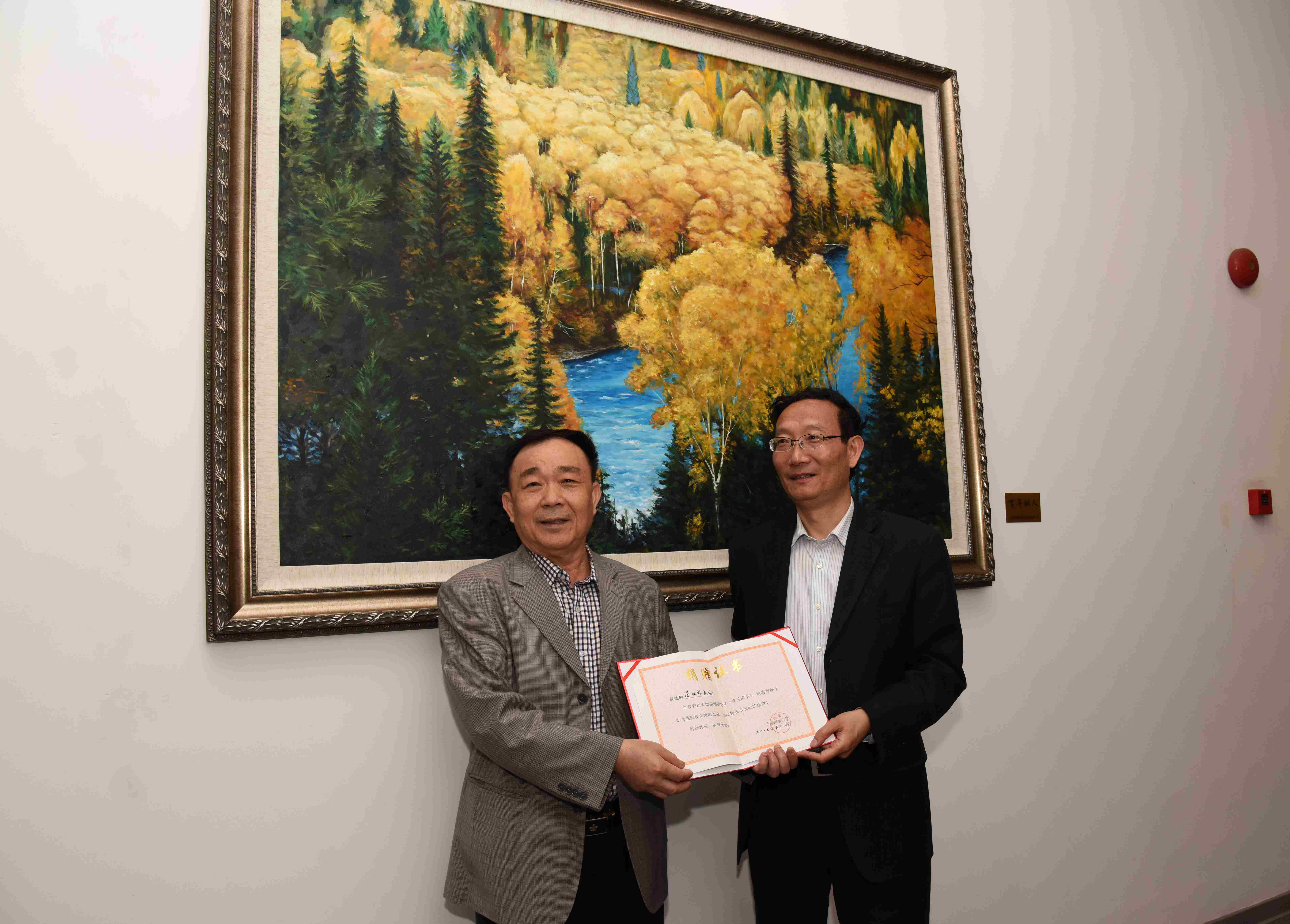 黃有方校長代表學校接受湛江校友會秘書長蔡法向母校捐贈的“百年樹人”油畫